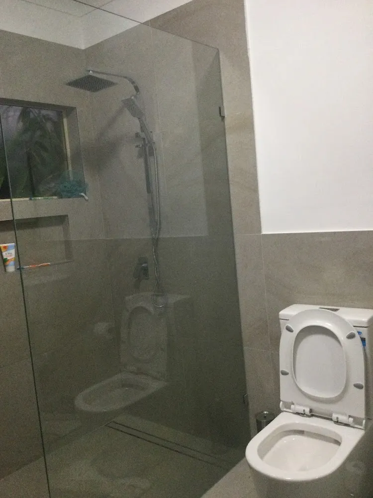 Renovated bathroom with a walk-in glass shower and stone-look wall tiles